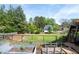 Expansive backyard featuring established garden beds, mature trees, and a wood fence at 3174 Country Club Nw Ct, Kennesaw, GA 30144