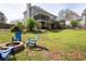 Green backyard with fire pit area and comfortable Adirondack chairs; ideal for cozy evenings at 3174 Country Club Nw Ct, Kennesaw, GA 30144