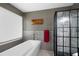 This bathroom boasts a sleek soaking tub and a modern glass shower, all enhanced by elegant gray tiling accents at 3174 Country Club Nw Ct, Kennesaw, GA 30144