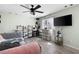 Bedroom with a ceiling fan, mounted television, gray wood floors and a neutral color palette at 3174 Country Club Nw Ct, Kennesaw, GA 30144