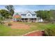 Charming home with inviting front porch, red brick, blue shutters, and lush landscaping at 3174 Country Club Nw Ct, Kennesaw, GA 30144
