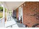Cozy front porch with brick wall, hanging chair, and decorative accents at 3174 Country Club Nw Ct, Kennesaw, GA 30144