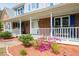 Inviting front porch with cozy seating, decorative accents, and flowering plants at 3174 Country Club Nw Ct, Kennesaw, GA 30144
