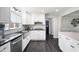 Contemporary kitchen features stainless appliances, white cabinets, a tile backsplash, and dark hardwood flooring at 3174 Country Club Nw Ct, Kennesaw, GA 30144