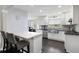 Bright kitchen features a marble countertop breakfast bar, stainless steel sink, and modern white cabinets at 3174 Country Club Nw Ct, Kennesaw, GA 30144
