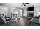 Living room featuring a fireplace, ceiling fan, dark hardwood floors, and French doors at 3174 Country Club Nw Ct, Kennesaw, GA 30144