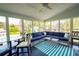 Bright sunroom featuring large windows with backyard views and a cozy seating area with blue cushions at 3174 Country Club Nw Ct, Kennesaw, GA 30144