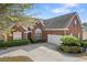 Red brick home with an attached garage and a well-maintained lawn at 3503 Dunbar Ln, Suwanee, GA 30024