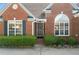 Close up of the brick facade entrance with tidy landscaping and a beautiful arched window above door at 3503 Dunbar Ln, Suwanee, GA 30024
