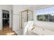 Bright bathroom features a glass-enclosed shower, soaking tub, and walk-in closet at 3503 Dunbar Ln, Suwanee, GA 30024