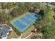Aerial view of well-maintained community tennis courts with vibrant blue surfaces and surrounding playground at 3503 Dunbar Ln, Suwanee, GA 30024