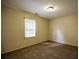 A carpeted bedroom has neutral paint and a window for natural light at 2048 Kelvin Dr, Lawrenceville, GA 30043