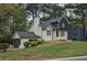 Charming white brick home with a dark garage door, well-maintained landscaping, and a brick pathway at 2048 Kelvin Dr, Lawrenceville, GA 30043