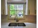 Kitchen sink boasts backyard views, stainless fixtures, and white subway tile backsplash at 2048 Kelvin Dr, Lawrenceville, GA 30043