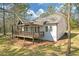 Side view of cozy home featuring a cozy front porch, white siding, and mature trees at 2095 Highway 20 Ne, Conyers, GA 30012