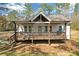 Charming home featuring a cozy front porch, white siding, and mature trees at 2095 Highway 20 Ne, Conyers, GA 30012
