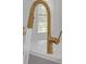Modern gold kitchen sink with pull-down sprayer and flowing water at 2095 Highway 20 Ne, Conyers, GA 30012