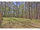 A large, grassy backyard featuring a storage shed with mature trees for extra privacy at 2806 Peachtree Walk, Duluth, GA 30096