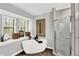 Bathroom with a soaking tub, a glass shower and natural lighting with wood look tile floors at 2806 Peachtree Walk, Duluth, GA 30096