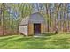 Backyard storage shed features ample storage, double doors, and a convenient lawn mower at 2806 Peachtree Walk, Duluth, GA 30096