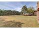 Spacious backyard with lush green grass, mature trees and shrubs, complemented by a fence at 5394 Brendlynn Dr, Suwanee, GA 30024