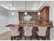 Basement bar with custom cabinets, decorative lighting, stone backsplash, and seating for three at 5394 Brendlynn Dr, Suwanee, GA 30024