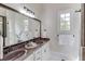 Bright bathroom featuring a double sink vanity with a large framed mirror at 5394 Brendlynn Dr, Suwanee, GA 30024