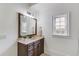 Well-lit bathroom with decorative mirror, vanity, and window at 5394 Brendlynn Dr, Suwanee, GA 30024