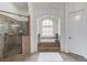 Luxurious primary bath showcasing a glass shower and soaking tub set beneath an arched window at 5394 Brendlynn Dr, Suwanee, GA 30024