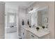 Bathroom featuring a white vanity with marble countertop, large mirror, and built-in bench by window at 5394 Brendlynn Dr, Suwanee, GA 30024