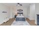 Bedroom with hardwood floors, neutral walls, ceiling fan, and a gray bed with Miami Heat decor at 5394 Brendlynn Dr, Suwanee, GA 30024
