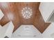 Detailed shot of a vaulted ceiling featuring decorative wood panelling and modern chandeliers at 5394 Brendlynn Dr, Suwanee, GA 30024