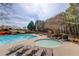 An inviting community pool and spa area with lounge chairs, tables, and lush landscaping at 5394 Brendlynn Dr, Suwanee, GA 30024