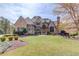 Grand brick home with lush lawn, mature trees, and professionally landscaped grounds at 5394 Brendlynn Dr, Suwanee, GA 30024
