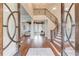 Elegant foyer featuring a grand staircase, wood flooring, and a stunning chandelier, with a view into the living room at 5394 Brendlynn Dr, Suwanee, GA 30024