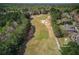 An aerial view showcases the golf course lot and beautiful homes surrounded by lush trees at 5394 Brendlynn Dr, Suwanee, GA 30024