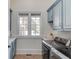 Clean laundry room with blue cabinets, stainless steel appliances, and window at 5394 Brendlynn Dr, Suwanee, GA 30024