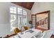 Home office with a large window, hardwood floors, wainscotting, and an ornate staircase behind at 5394 Brendlynn Dr, Suwanee, GA 30024