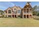 Back of a large brick home with a covered porch and manicured lawn perfect for outdoor gatherings at 5394 Brendlynn Dr, Suwanee, GA 30024