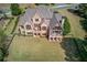 An aerial view showcases the home's rear exterior, covered porch, balcony, and spacious yard at 5394 Brendlynn Dr, Suwanee, GA 30024