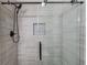 Contemporary shower featuring glass doors, gray tiled walls, and a built-in shelf at 5394 Brendlynn Dr, Suwanee, GA 30024