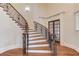 An ornate staircase with hardwood steps and floors plus a wrought iron banister at 5394 Brendlynn Dr, Suwanee, GA 30024