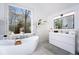A luxurious bathroom with a freestanding tub, modern vanity, and large window with natural light at 85 Cliffside Crossing, Atlanta, GA 30350
