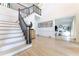 Bright foyer with hardwood floors, a staircase with dark rails, and an open view to the living room at 85 Cliffside Crossing, Atlanta, GA 30350