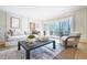 Cozy living room with a large window, hardwood floors, a comfortable sofa, and elegant decor at 85 Cliffside Crossing, Atlanta, GA 30350