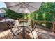 The outdoor deck includes a dining table, seating, a shade umbrella, and wooded views at 1107 Fieldstone Dr, Canton, GA 30114