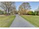 Long driveway leading up to a charming home surrounded by trees on a well-maintained lawn at 1880 Ridgedale Dr, Snellville, GA 30078