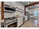 Eat-in kitchen with stainless appliances, open shelving, granite countertops, and white cabinetry at 1880 Ridgedale Dr, Snellville, GA 30078