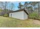 A functional white outbuilding on a vast lawn with a metal roof and access door at 1880 Ridgedale Dr, Snellville, GA 30078