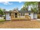 Well-maintained white home featuring a cozy wood porch, black trim, and a neatly mulched front yard at 2297 Sheryl Dr, Decatur, GA 30032